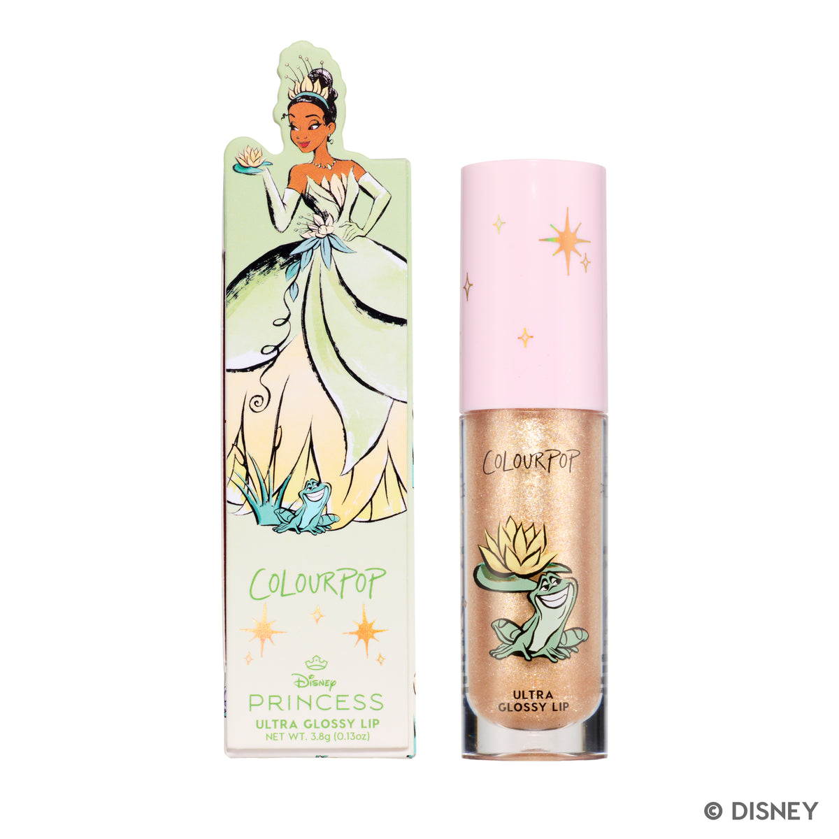ColourPop Ambitious Tiana Ultra Glossy Lip tube standing beside its pastel green Disney Princess box featuring Tiana in her ball gown and frog artwork, showcasing the shimmery gold lip gloss packaging for US beauty fans.
