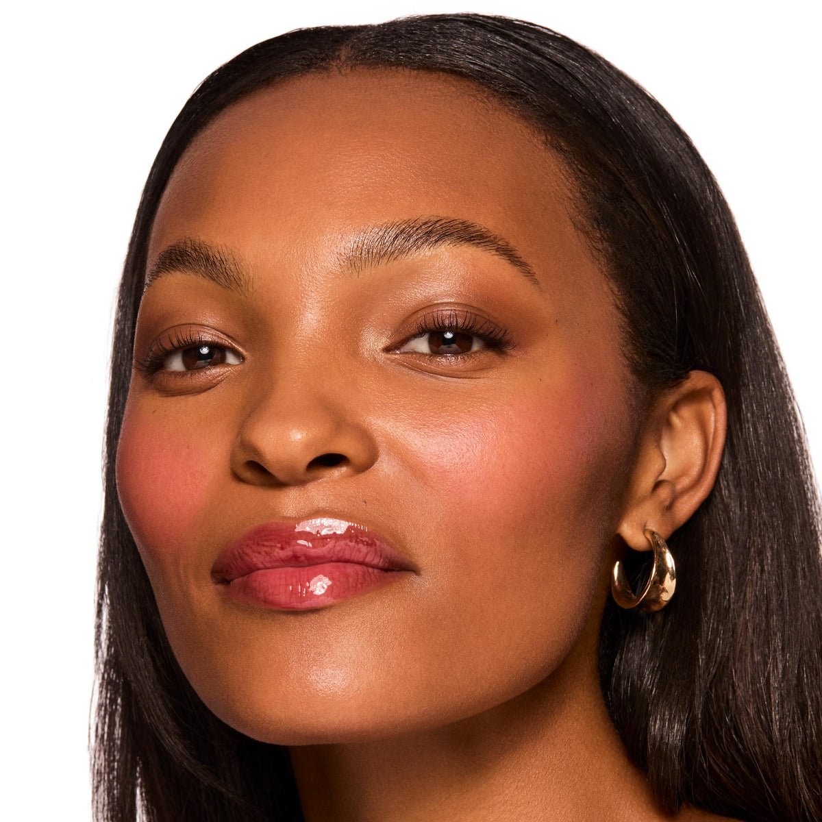 Glossy berry-tinted lips showcase ColourPop Fresh Kiss Glossy Balm in Wild Berry, high-shine finish on a model’s close-up face with soft blush and a gold hoop earring against a clean white background.