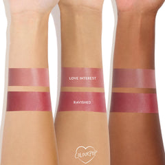 Love Interest ColourPop Lip and Cheek Balm swatched on three skin tones, with two stacked stripes per arm labeled Love Interest and Ravished, showing a dewy rosy-mauve finish and buildable multi-use coverage on a white studio background.