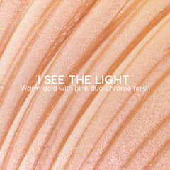 I See the Light ColourPop Liquid Highlighter swatched in sweeping ridges, showing a warm gold base with pink duochrome shimmer; creamy liquid texture gleams under light in a close-up macro for a luminous glow.