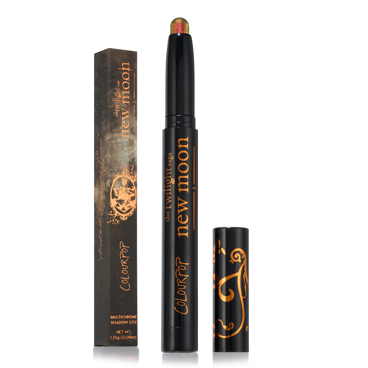 Vampire Girl ColourPop Shadow Stix stands uncapped, revealing a multichrome green-to-red shimmer tip, with its black cap and matching New Moon Twilight collab box beside it, both in black with copper-gold graphics, on a white backdrop.