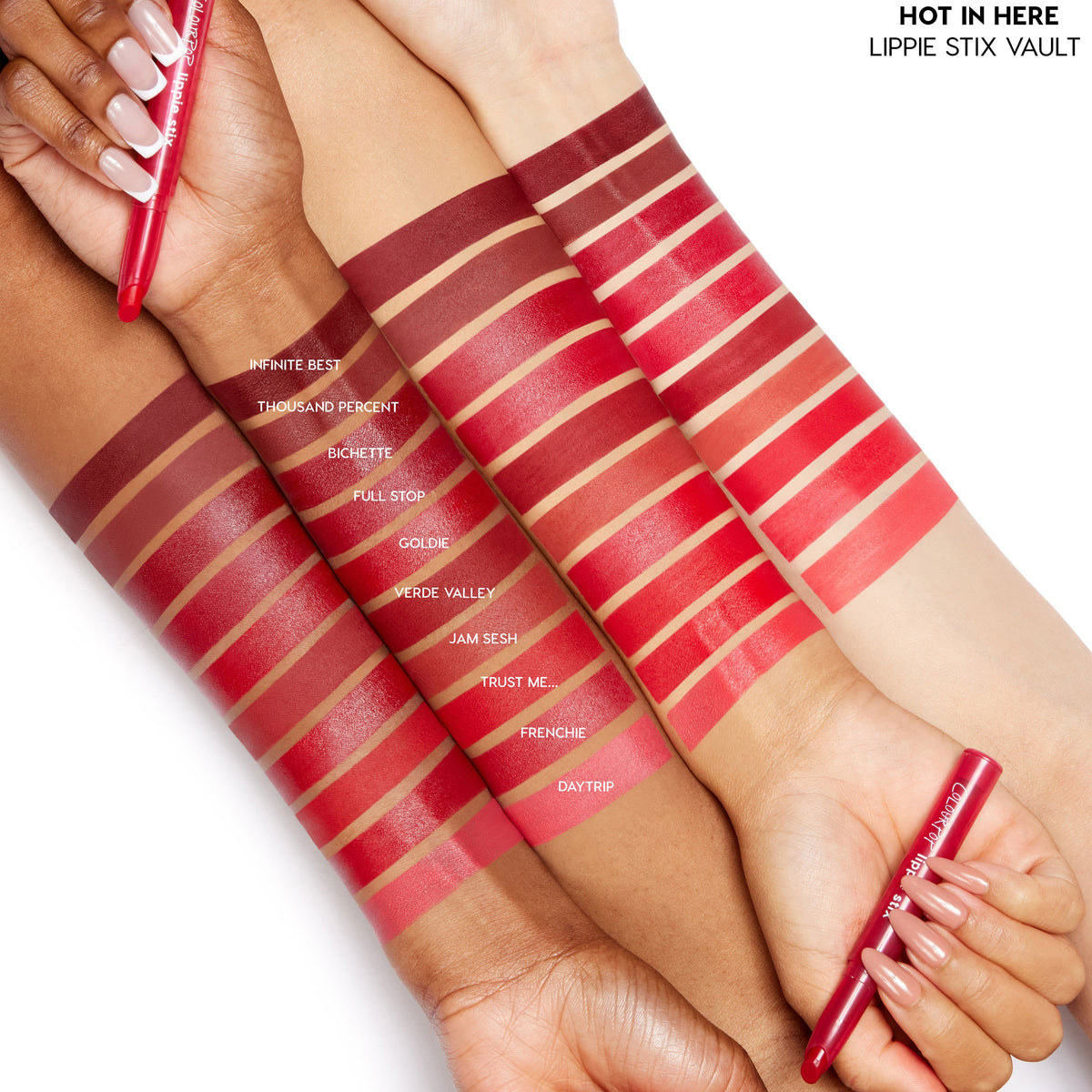 ColourPop Lippie Stix Hot in Here Vault swatches sweep across three skin tones, showing 10 reds from deep burgundy to bright coral (Infinite Best to Daytrip), as hands hold red Lippie Stix pens on a white studio background.